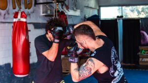 Rękawice do MMA różnych marek na macie treningowej, porównanie